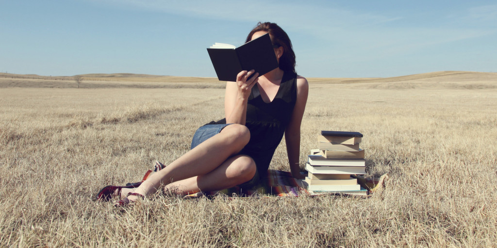 Woman reading books in an open field